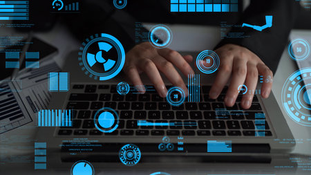 A close-up view of hands typing on a laptop surrounded by vibrant digital data visualizations. This...