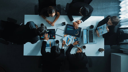 Top down aerial view of smart project manager present growth graph while marketing team analyze...