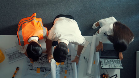 Top down view of project manager and civil engineer hold laptop while explain idea to architect....