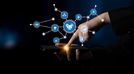 A hand interacting with a smartphone displaying various interconnected icons, representing the...