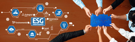 Teams collaborate on ESG principles centered on green business strategies on a wooden table. The image conveys a commitment to sustainable practices and corporate governance initiatives. Amityのeditorial素材