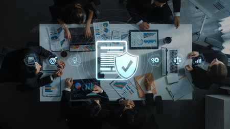 A diverse business team collaborates on data security strategies using charts and graphs in a modern...