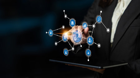 A business professional uses a tablet to interact with digital network icons, showcasing technology...