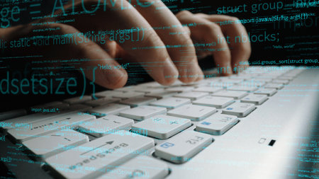 A detailed view of hands typing on a white keyboard, surrounded by digital code and programming...