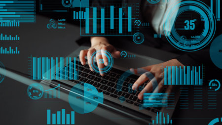 A business professional types on a laptop surrounded by digital graphics representing data analysis,...