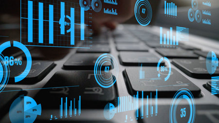 A detailed close-up image showcasing a laptop keyboard enhanced with digital graphs and charts, symbolizing the intersection of technology and data analysis in business.の写真素材