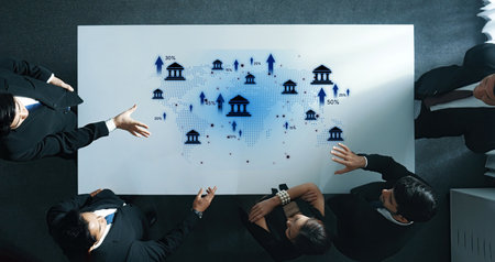A diverse group of professionals engages in a business meeting around a conference table adorned with data visualizations showcasing financial growth and strategic insights.の写真素材