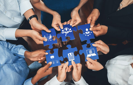 This image illustrates diverse hands working together to connect puzzle pieces, symbolizing...
