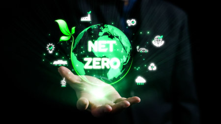 A professional hand holds a glowing green globe featuring the concept of net zero, surrounded by eco-friendly icons. This image symbolizes sustainability and environmental awareness.の写真素材