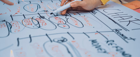 A group of hands engaged in a creative brainstorming session, working together on colorful charts...
