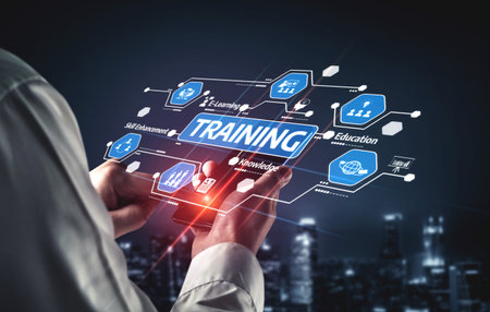 A professional holds a mobile device displaying a training concept with digital graphics, symbolizing innovation in education and skill development in a modern business environment. Tesselの写真素材