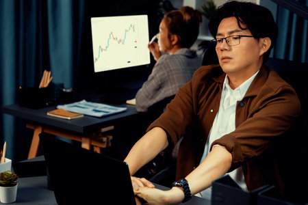 Sales manager working on desk with stretching arm up and down manner with body health ache of strain...