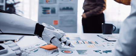 A robotic hand engages with business charts in a modern office setting, illustrating the...