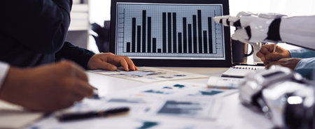 A professional business meeting featuring data analysis with financial graphs, modern technology,...