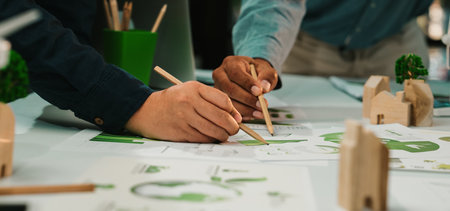 Hands of diverse professionals engaged in collaborative design work, exploring sustainable solutions...