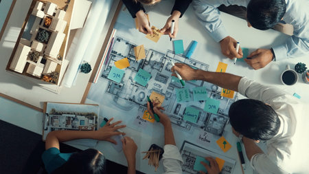 Top aerial view of project manager or civil engineer writing at blueprint and planning building...