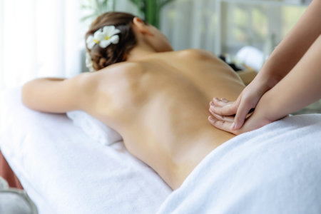 Caucasian woman customer enjoying relaxing anti-stress spa massage and pampering with beauty skin recreation leisure in day light ambient salon spa at luxury resort or hotel. Quiescentの写真素材