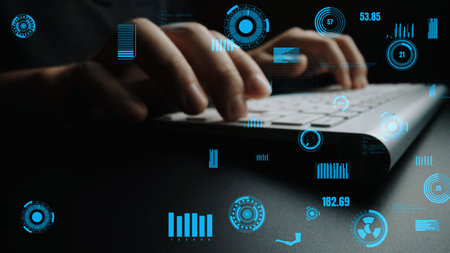 A close-up view of hands typing on a keyboard, surrounded by blue digital interface elements and...