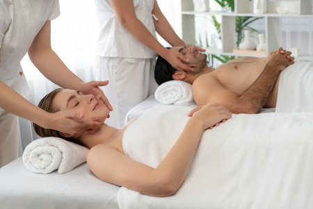 Caucasian couple enjoying relaxing anti-stress head massage and pampering facial beauty skin...