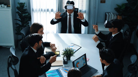 Top view of manager working on laptop and sending data analysis to business people by using VR glass...