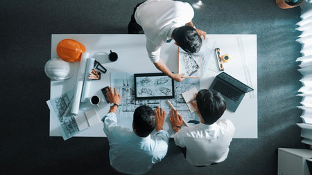 Top down view of professional manager look at plan while designer hold blueprint while present...