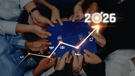 A diverse team unites around puzzle pieces to symbolize collaboration and strategic growth, focusing on achieving business goals and innovation for 2026. Rasterの写真素材