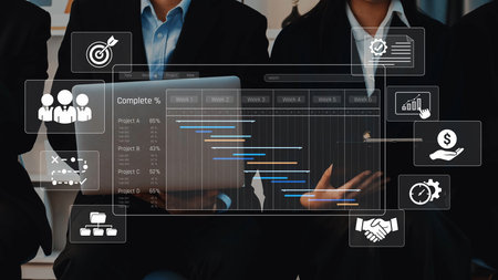 A modern business team engages with digital analytics on laptops, showcasing project management and collaboration in a professional office environment. Rasterの写真素材
