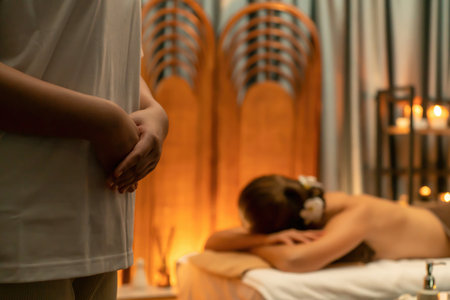 Caucasian woman customer enjoying relaxing anti-stress spa massage and pampering with beauty skin recreation leisure in warm candle lighting ambient salon spa at luxury resort or hotel. Quiescentの写真素材