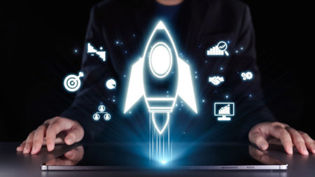 A modern business person interacts with a laptop while a rocket icon symbolizes innovative growth strategies, reflecting ambition and progress in the digital landscape.の写真素材