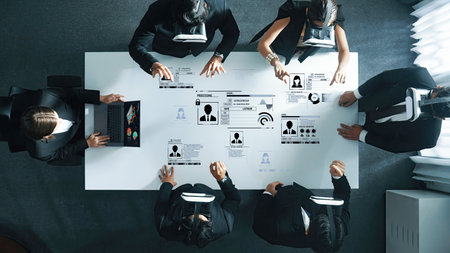 A diverse group of professionals collaborating in a modern office setting, utilizing virtual reality technology to enhance productivity and analyze important data during a meeting.の写真素材
