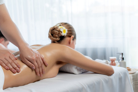 Caucasian couple customer enjoying relaxing anti-stress spa massage and pampering with beauty skin recreation leisure in day light ambient salon spa at luxury resort or hotel. Quiescentの写真素材