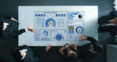 A business team engages in detailed analysis of a smart home dashboard displaying key data for...