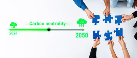 Diverse hands work together to fit blue puzzle pieces, symbolizing the journey towards carbon neutrality from 2024 to 2050. An engaging visual representing teamwork for a sustainable future.の写真素材