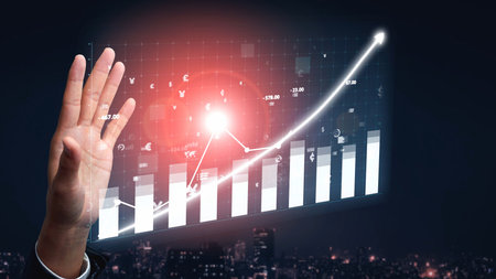 A professional hand gestures toward a digital graph showcasing financial growth and data analysis, symbolizing success and innovation in business.の写真素材