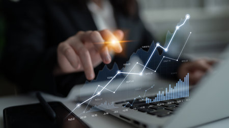 A professional person interacts with a laptop, showcasing financial data and growth charts, emphasizing modern technology in business analysis and market research.の写真素材