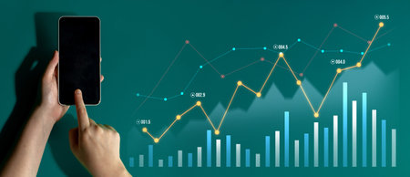 A person interacts with a smartphone displaying financial graphs and charts on a vibrant digital...