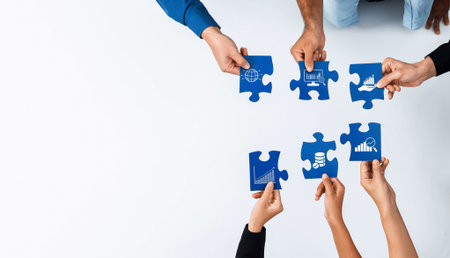Diverse team members engage in a collaborative puzzle-solving activity, highlighting business analytics strategies and insights crucial for corporate growth.の写真素材