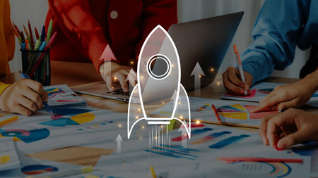 A vibrant office scene showcasing a team engaged in creative collaboration. Colorful charts and a rocket symbol illustrate innovative strategies and growth potential. Rasterの写真素材