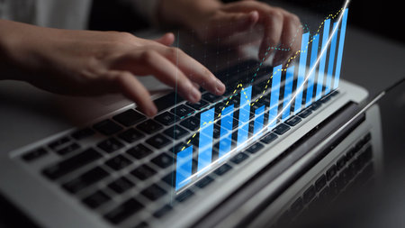 A close-up of hands typing on a laptop keyboard, enhanced with a digital graph overlay representing business growth and financial analysis, ideal for tech and finance themes.の写真素材
