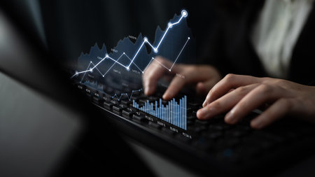 A focused person typing on a keyboard, with digital financial graphs and data visualizations overlaying, illustrating market trends and analytics in a modern workspace.の写真素材