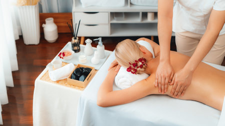 Caucasian woman customer enjoying relaxing anti-stress spa massage and pampering with beauty skin recreation leisure in day light ambient salon spa at luxury resort or hotel. Quiescentの写真素材
