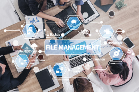 A professional team collaborates on innovative file management solutions using digital devices, emphasizing cloud storage and backup strategies for business efficiency. Tesselの写真素材