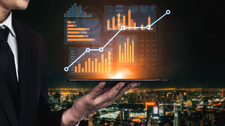 A businessman holds a tablet displaying vibrant data visualizations against a night cityscape,...