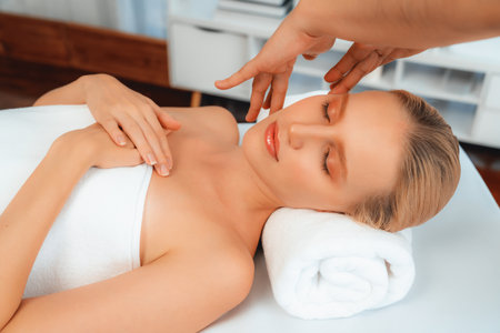 Caucasian woman enjoying relaxing anti-stress head massage and pampering facial beauty skin recreation leisure in dayspa modern light ambient at luxury resort or hotel spa salon. Quiescentの写真素材