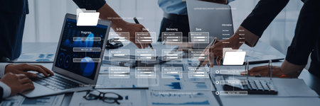 A dynamic business team collaborates in a modern office, using laptops and data analytics to enhance...