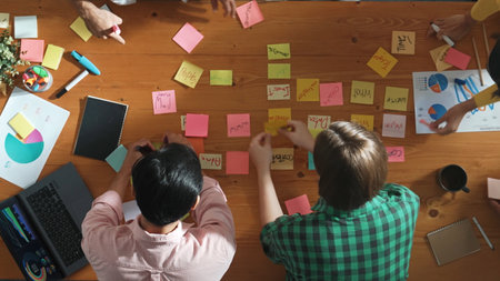 Top view of business team choose brainstorming idea and stick sticky notes at meeting table. Group of diverse people working together sharing idea by using notes and equipment at table. Convocation.の写真素材