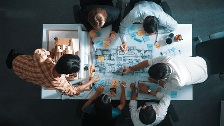 Top aerial view of project manager or civil engineer writing at blueprint and planning building...