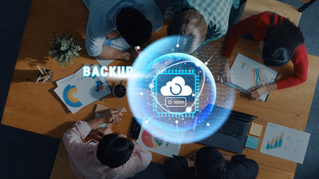 A diverse group of professionals collaborates in a modern office setting, focusing on cloud backup solutions and data security strategies during an engaging meeting.の写真素材