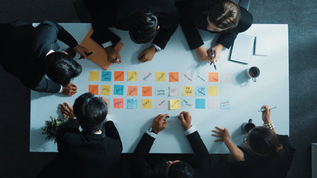 Smart cooperate business people writing and brainstorming business idea by using sticky notes. Top...
