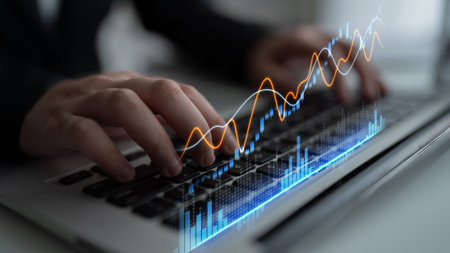 A professional business scene with hands typing on a laptop, displaying finance charts and graphs...